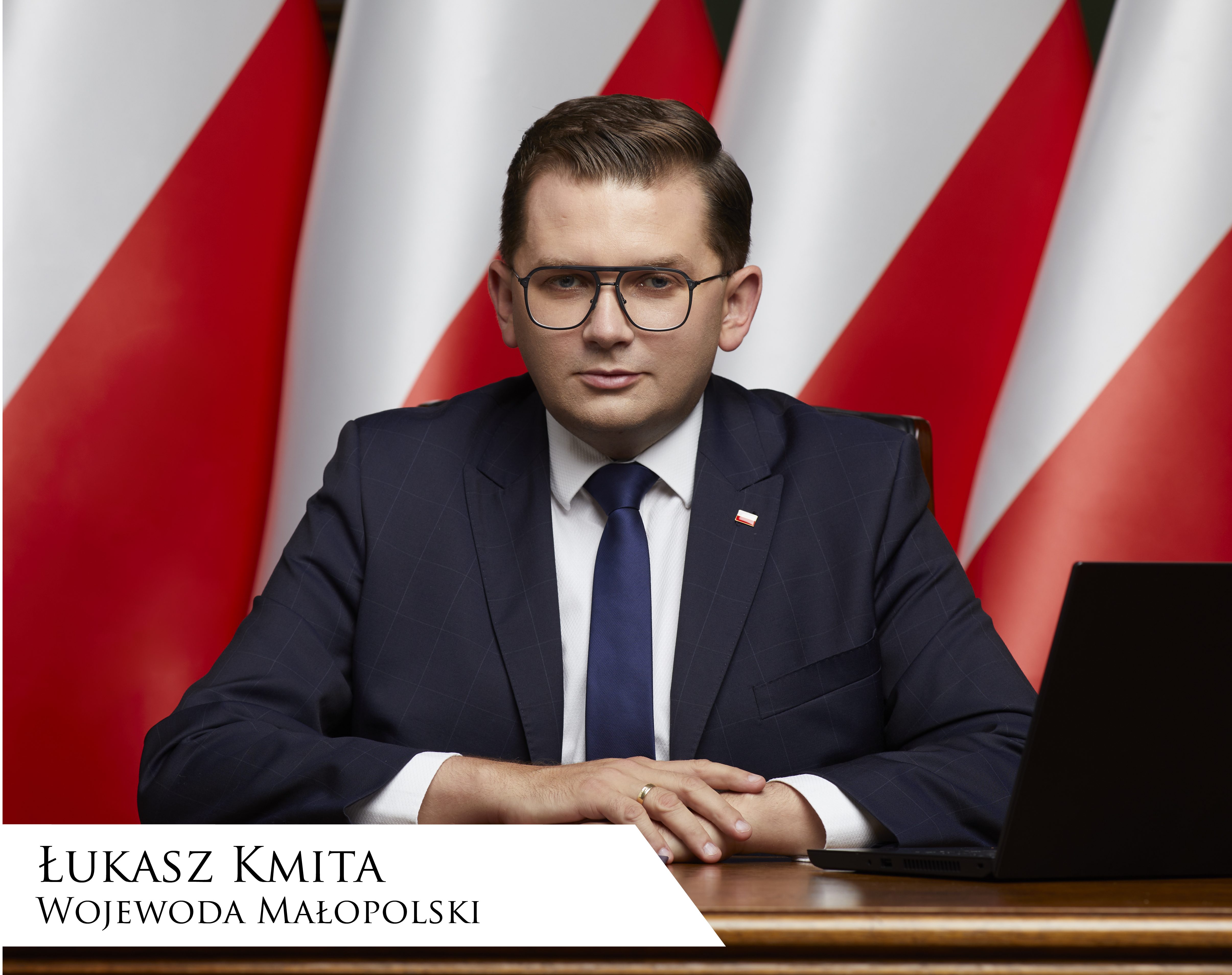 Łukasz Kmita, Wojewoda Małopolski siedzący przy biurku na tle flag Polski